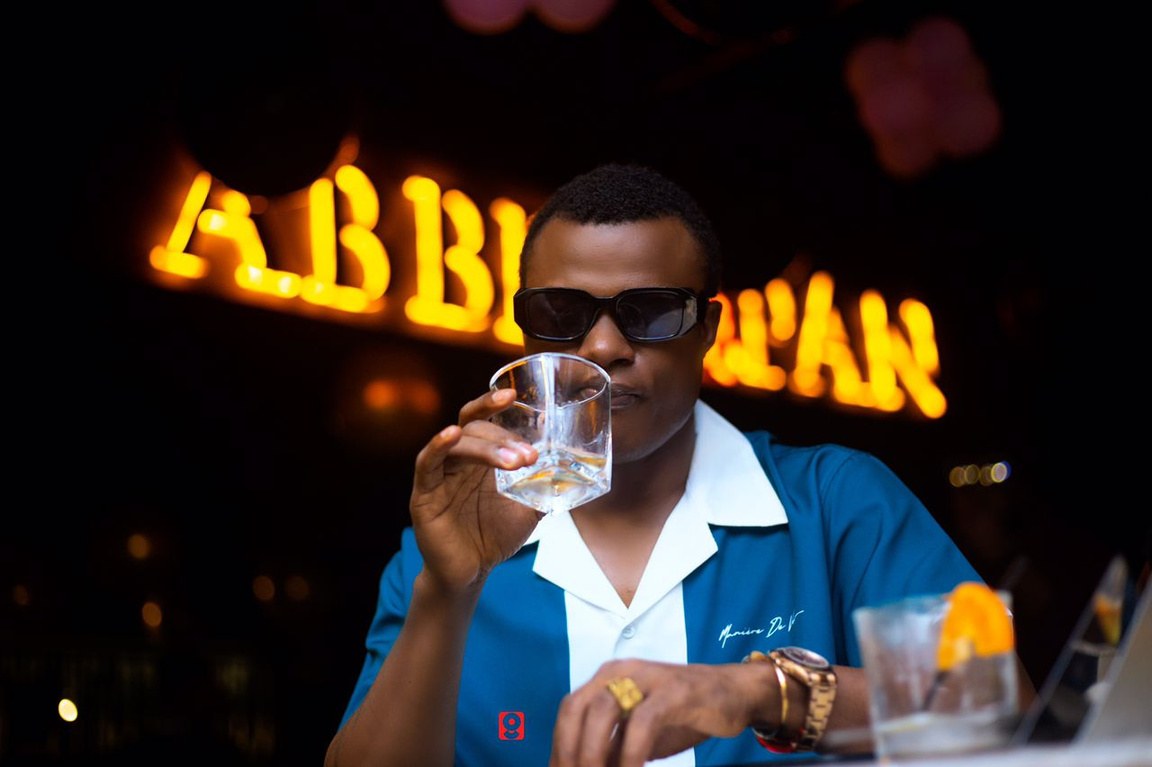 DJ Kenny raising a glass under the AbbeynPan sign